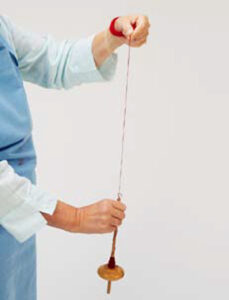 person holding fresh spun yarn under tension